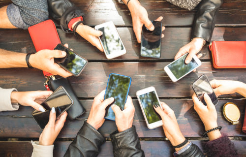 Hands holding mobile phones - designed to depict many people logging in